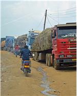 700 LKWs donnern über die Piste, die mitten durch die staatenübergreifende Stadt Mutukula führt, oder warten stundenlang, um die Grenze zu passieren. Foto: LPA/V.Bussadori
